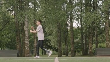 Genç sporcunun tek başına futbol sahasında antrenman yaparken ters takla attığı geniş açı.