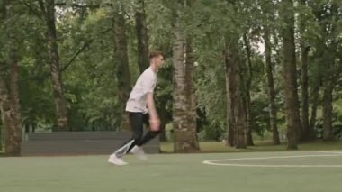 Açık hava futbol sahasında akrobatik hareketler yaparken takla atan genç bir amigo kız resmi.