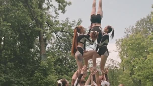 在足球场进行户外运动时 啦啦队表演了两个半高的金字塔 把女青年倒立在空中 — 图库视频影像