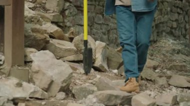 Ev onarımı için ekipman hazırlarken yaşlı bir kişinin taş atmasını yukarı kaldır