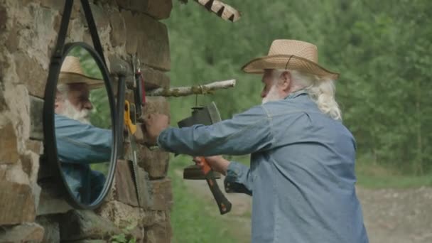 Yaşlı Bir Adamın Evinin Duvarına Balta Asmak Için Çivi Çaktığı — Stok video