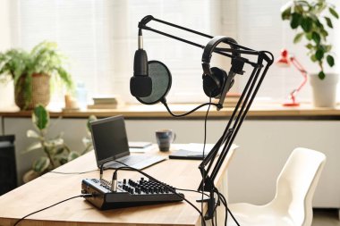 Bir grup podcast ekipmanı ve malzeme modern ev sahibinin iş yerinde geniş bir iç oda veya stüdyo içinde duruyor.