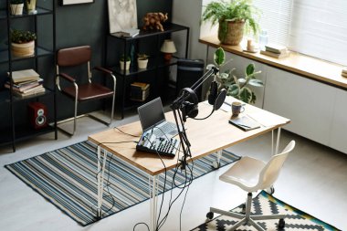 Radyo sunucusunun iş açısının üstünde ses kaydı ve yayın için çeşitli ekipmanlar gerekli.