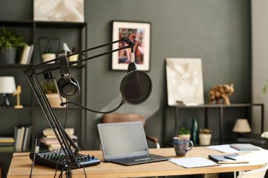 Modern blogcu, radyo sunucusu ya da stüdyoda DJ 'lik yapan ses kayıt cihazlarıyla çevrili bir laptop.