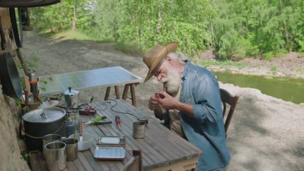 Longo Tiro Médio Homem Sênior Com Tubo Fumar Reparar Painel — Vídeo de Stock