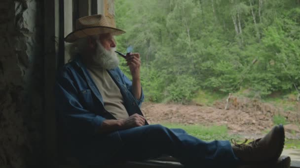 Střední Dlouhý Záběr Uvolněného Důchodce Sedícího Uvnitř Nedokončeného Stavebního Kouřícího — Stock video