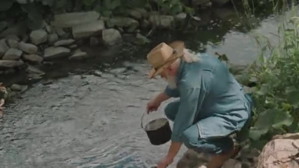 Mittelweite Aufnahme Eines Älteren Mannes Der Sauberes Flusswasser Topf Sammelt — Stockvideo