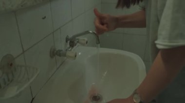Yüzünde morluklar olan güçlü bir kadının aynanın önünde durduğu pozu çek.