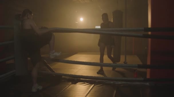 ジムでの競技前にトレーニング中にボクシングリングに行く女性の長いショット — ストック動画