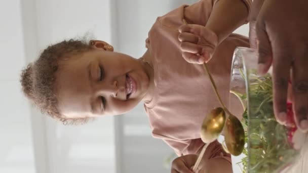 Вертикальный Снимок Милой Афроамериканской Девушки Улыбающейся Смешивающей Овощной Салат Стеклянной — стоковое видео