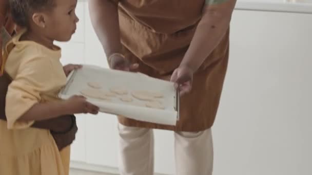 African American Parents Little Daughter Placing Tray Cookies Hot Oven — Stock Video