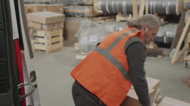 Depoda çalışırken paketleri kargo kamyonuna koyan adamı aşağı doğru çek.