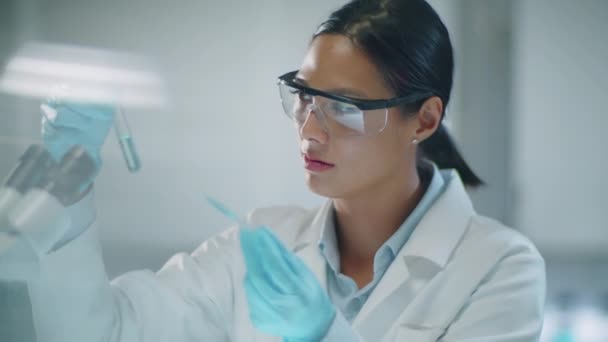 코트에 아시아 화학자의 테스트 튜브에 물질을 반응을 — 비디오