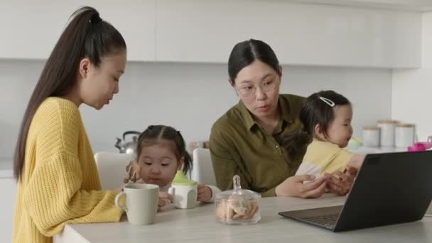 Δύο Νεαρές Ασιάτισσες Μαμάδες Χαριτωμένη Κορούλα Κοιτάζουν Laptop Και Συζητούν — Αρχείο Βίντεο