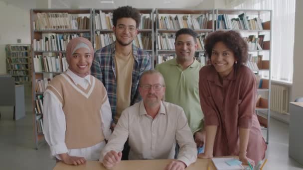 现代图书馆多民族青年移民学生及其成年高加索男教师拍照的中速肖像 — 图库视频影像