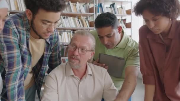 Yetişkin Beyaz Erkek Öğretmenin Çeşitli Genç Göçmen Öğrencilerin Dijital Tablet — Stok video