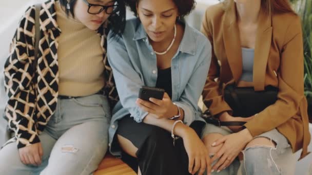 Odchyl Się Młodej Afroamerykanki Patrzącej Smartfona Rozmawiającej Wielorasowymi Dziewczynami Siedzącej — Wideo stockowe