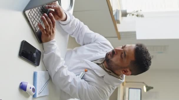 Orta Doğu Erkek Doktorunun Modern Tıp Ofisinde Dizüstü Bilgisayarla Çalışırken — Stok video