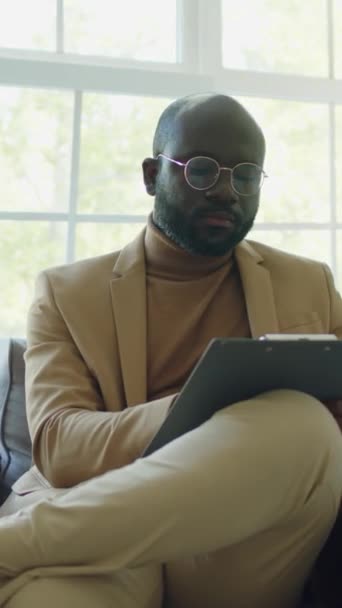 Вертикальний Знімок Афроамериканського Психолога Який Сидить Своєму Кабінеті Робить Нотатки — стокове відео