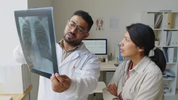 Талия Ближневосточного Специалиста Рентгенолога Осматривающего Легкие Латинской Пациентки Беседующего Современном — стоковое видео