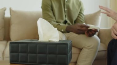 Destekleyici kadın terapistin, Afrika kökenli Amerikalı erkek müşterinin elini tutarken, danışmanlık seansında onu rahatlatırken çekilmiş bir portre fotoğrafı.