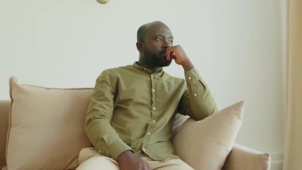 Pensativo Hombre Afroamericano Sentado Sofá Mirando Lado Pensativamente Después Sesión — Vídeo de stock