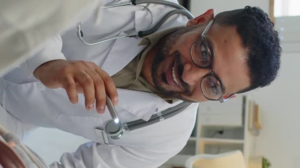Pionowe Spowolnienie Bliskowschodniego Lekarza Okularach Latarką Podczas Sprawdzania Oczu Gardła — Wideo stockowe