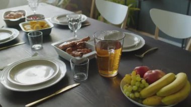 Kutlama için yemek masasında servis edilen şenlikli yemek, içecek, meyve, kızarmış tavuk ve mısır ile birlikte sürahi var.