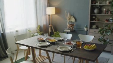 Evdeki akşam yemeği için sofrada şenlik yemekleri olan oturma odasının içinde kimse yok.