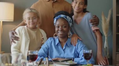 Afro-Amerikan ailenin mutlu bir şekilde fotoğraf çektirip gülümseyerek fotoğraf çektirirken evde şenlikli bir akşam yemeği yiyoruz.