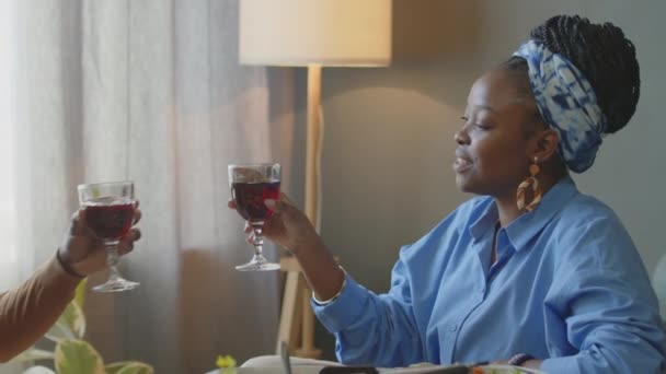 아프리카계 미국인 커플은 집에서 식사에 와인과 토스트와 클링킹 안경을 말한다 — 비디오