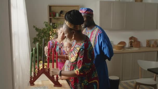 아프리카계 미국인 어머니는 키나라에 촛대를두고 콴자아 장식하는 남편에게 의미를 — 비디오