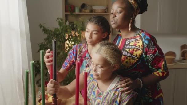 Niñas Afroamericanas Poniendo Candelabros Kinara Mientras Ayudan Madre Con Decoración — Vídeo de stock