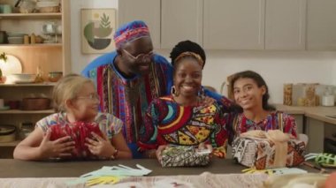 Neşeli Afro-Amerikan ailelerinden uzaklaşın. Dashiki kıyafetleri giyin. Gülümseyin ve kameraya poz verin.