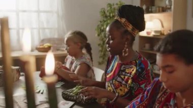 Afrika kökenli Amerikalı bir kadının Dashiki kaftan ve başörtüsüyle Kwanzaa tatilinde ailelerine hediye paketlerken konuştuğu yüksek açılı bir fotoğraf.