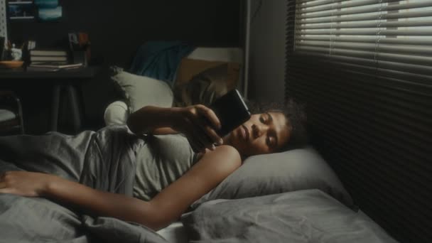 紧张的非洲裔美国少女晚上躺在床上 一边打电话一边哭泣 一边遭受网络欺凌 — 图库视频影像