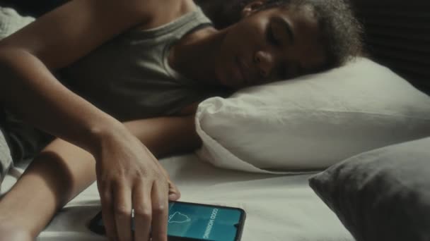 忧心忡忡的少女晚上躺在床上 在智能手机上接收讯息 阅读讯息 并对网络欺凌感到不安 — 图库视频影像