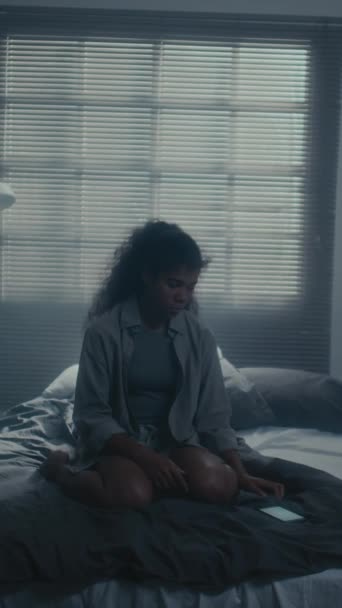 Tiro Vertical Chica Negra Edad Adolescente Sentada Cama Habitación Oscura — Vídeo de stock