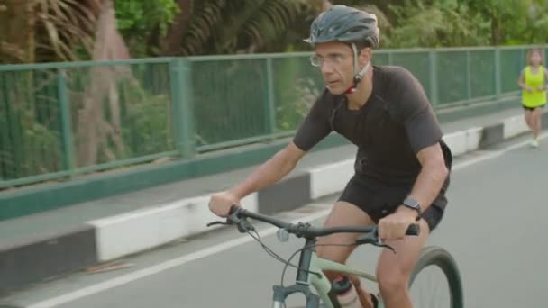 夏季骑自行车时 父亲和十几岁的儿子戴着头盔 身穿运动服 在户外骑车 — 图库视频影像