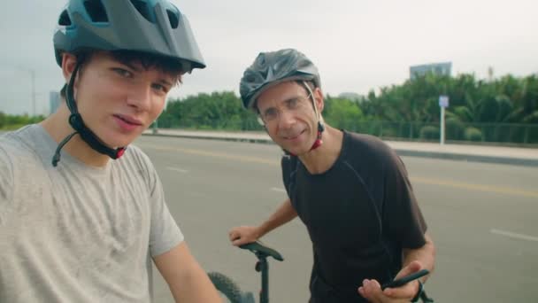 拍摄青少年男孩和他的父亲在户外骑车时看着相机 一边笑一边说话的Pov照片 — 图库视频影像