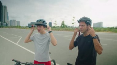 Baba ve oğulun kasklarını takıp bisiklet sürerken çekilen görüntüleri.