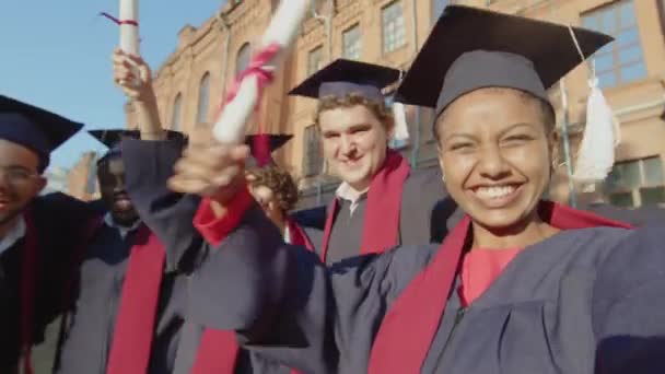 大学の卒業式を祝いながらセルフィーを取る多文化の若い友人のグループのPov — ストック動画