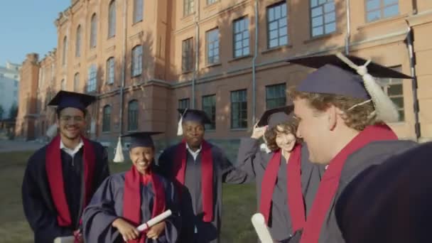 Pov Shot Estudiantes Graduados Multiculturales Tomando Selfie Gadget Pie Contra — Vídeo de stock