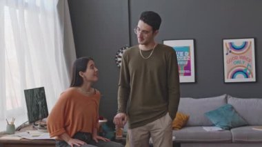 Evde kayıt stüdyosunda gülümseyen ve kamera önünde poz veren genç erkek ve kadın müzisyenlerin portresi.