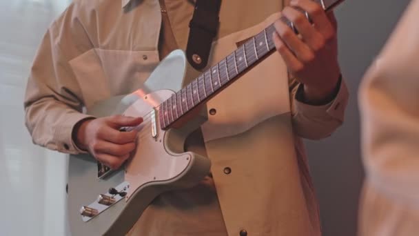 音楽バンドとしてリハーサルをしながらギターと女の子を演奏する男のクロップショット — ストック動画