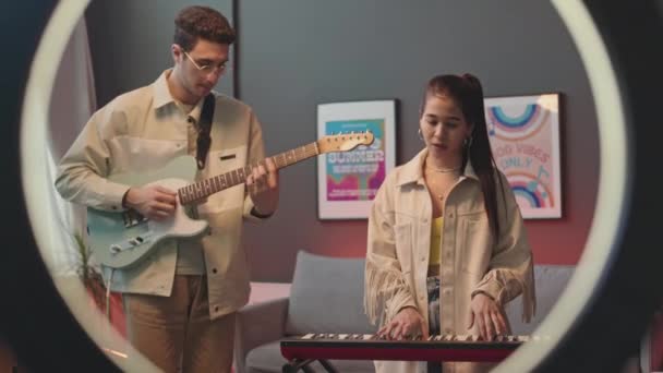 Stüdyosunda Genç Bir Çiftin Gitar Sentezleyici Şarkıları Eşliğinde Halka Işığına — Stok video