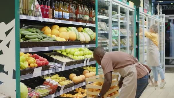 Tiro Medio Joven Negro Trabajador Tienda Comestibles Que Pone Naranjas — Vídeos de Stock