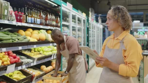 재고와 배경에 선반에 신선한 오렌지를 태블릿을 식료품 노동자의 — 비디오