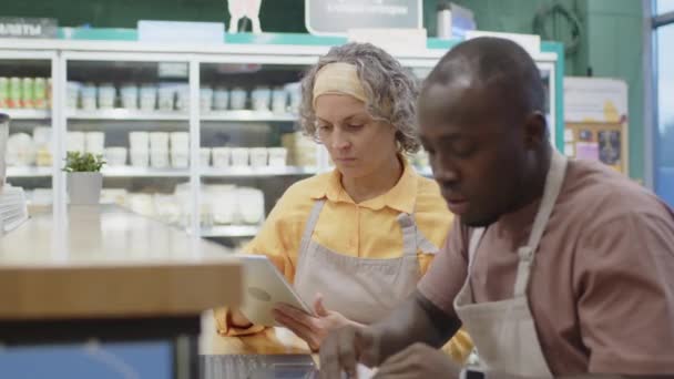 Mittlere Aufnahme Von Zwei Multiethnischen Supermarktmitarbeitern Die Tisch Sitzen Während — Stockvideo