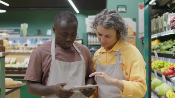 Mittleres Porträt Zweier Unterschiedlicher Männlicher Und Weiblicher Supermarktangestellter Schürzen Die — Stockvideo